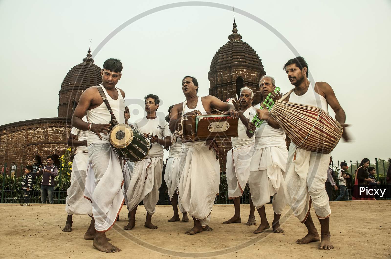 The folk singers of Bengal perform in front of a temple.