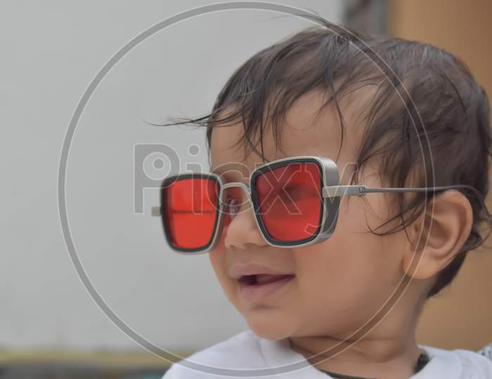 smiley face of  little baby in red sunglasses