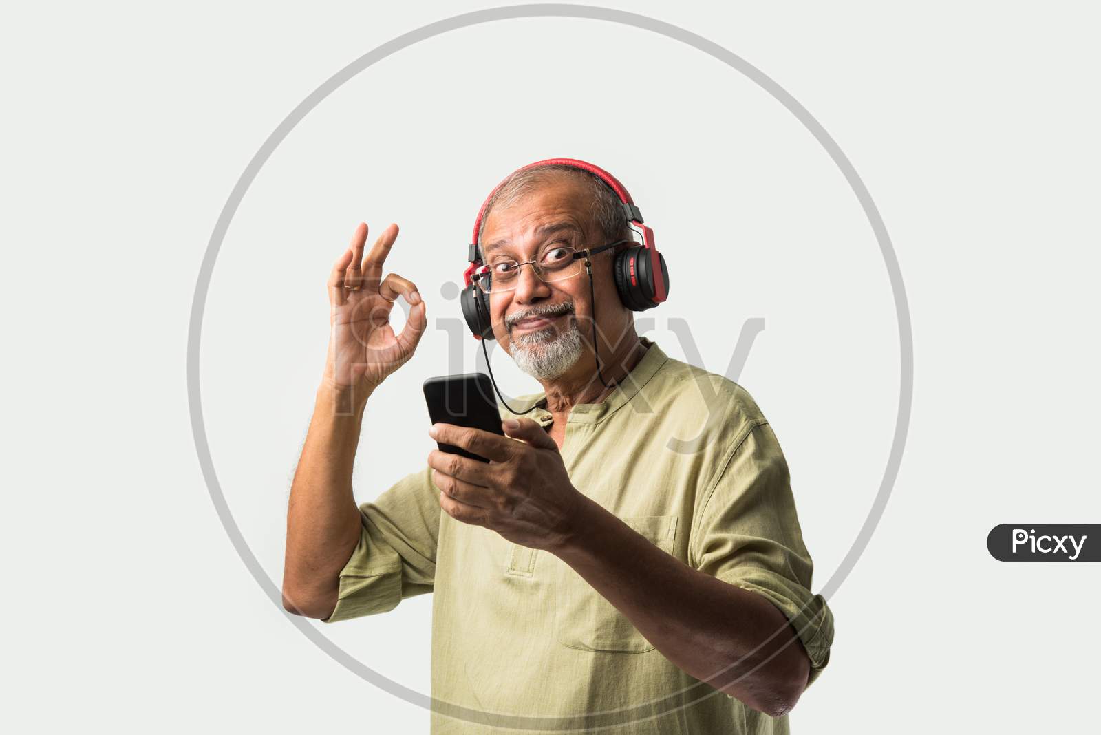 Indian Asian Senior Or Old Man Using Headphones With Smartphone Or Tablet, And Dancing