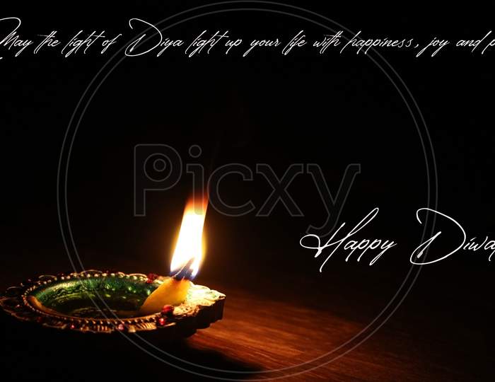 Illustration of happy Diwali wish card greeting with a glowing oil lamp