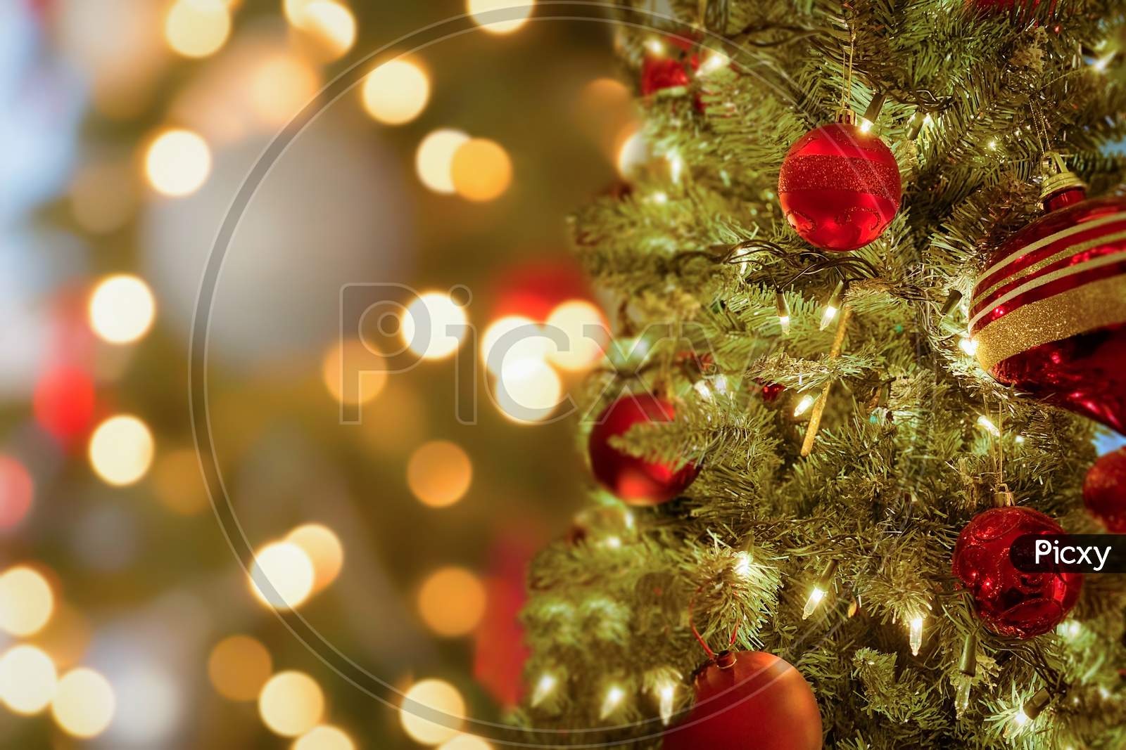 Close up of Christmas tree and balls. Bokeh garlands in the background. New Year concept.