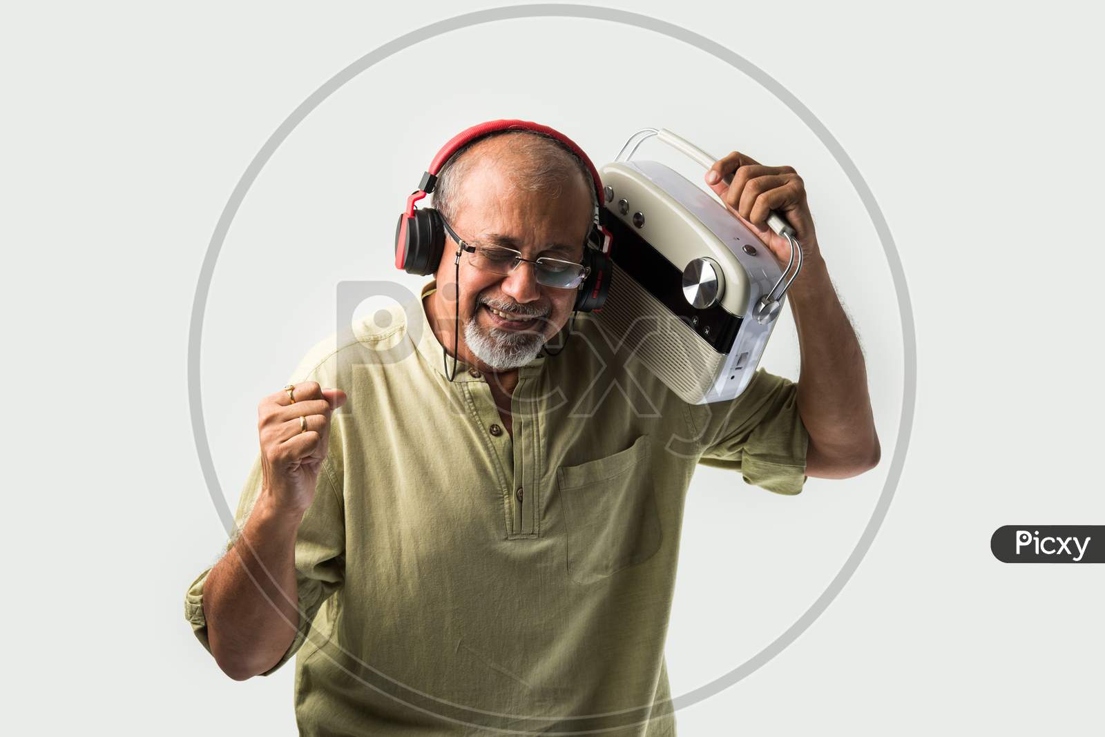 Indian Asian Retired Senior Man Listening Music On Retro Style Radio With Headphones And Dancing