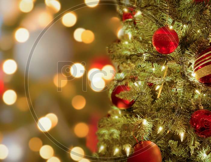 Close up of Christmas tree and balls. Bokeh garlands in the background. New Year concept.