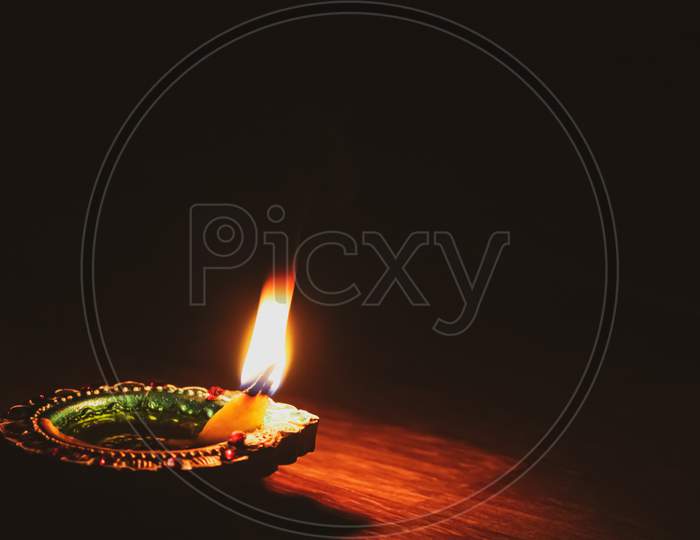 A burning candle on a black background