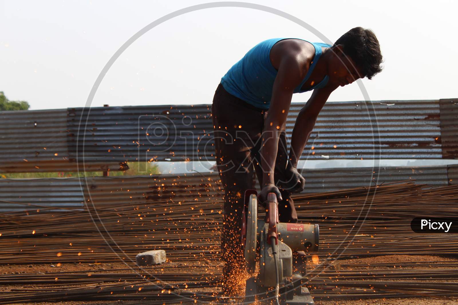 Man cutting iron rods for construction