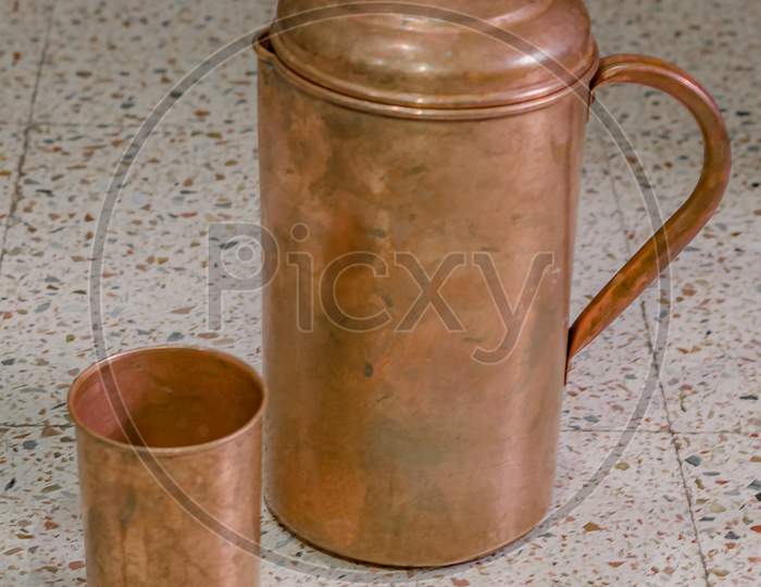 A copper jug and glass