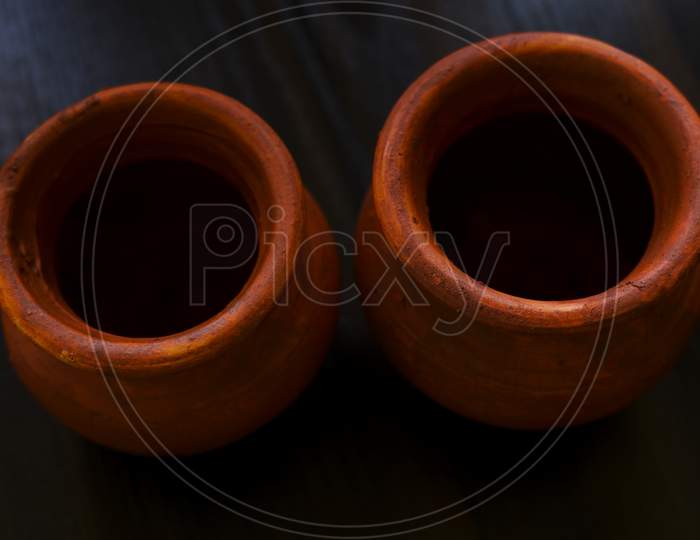 Top Shot Of Handmade Small Clay Pots Isolated On Wooden Table