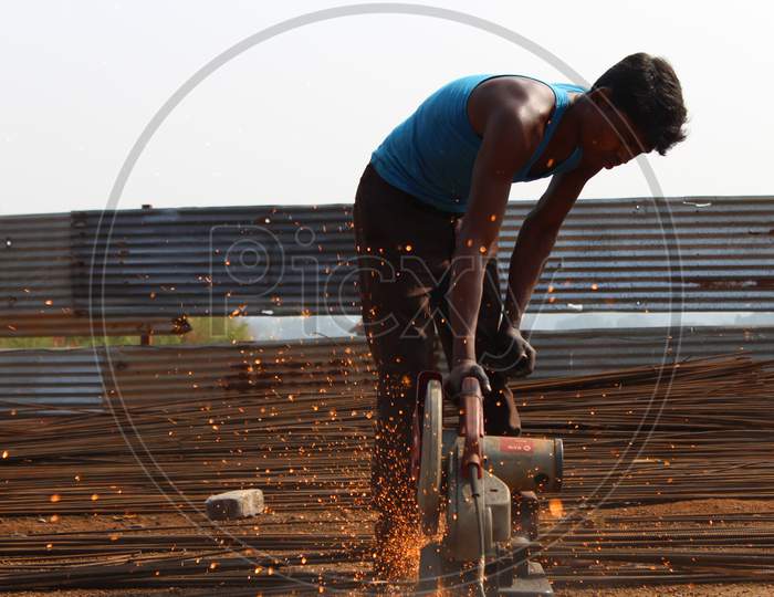 Man cutting iron rods for construction