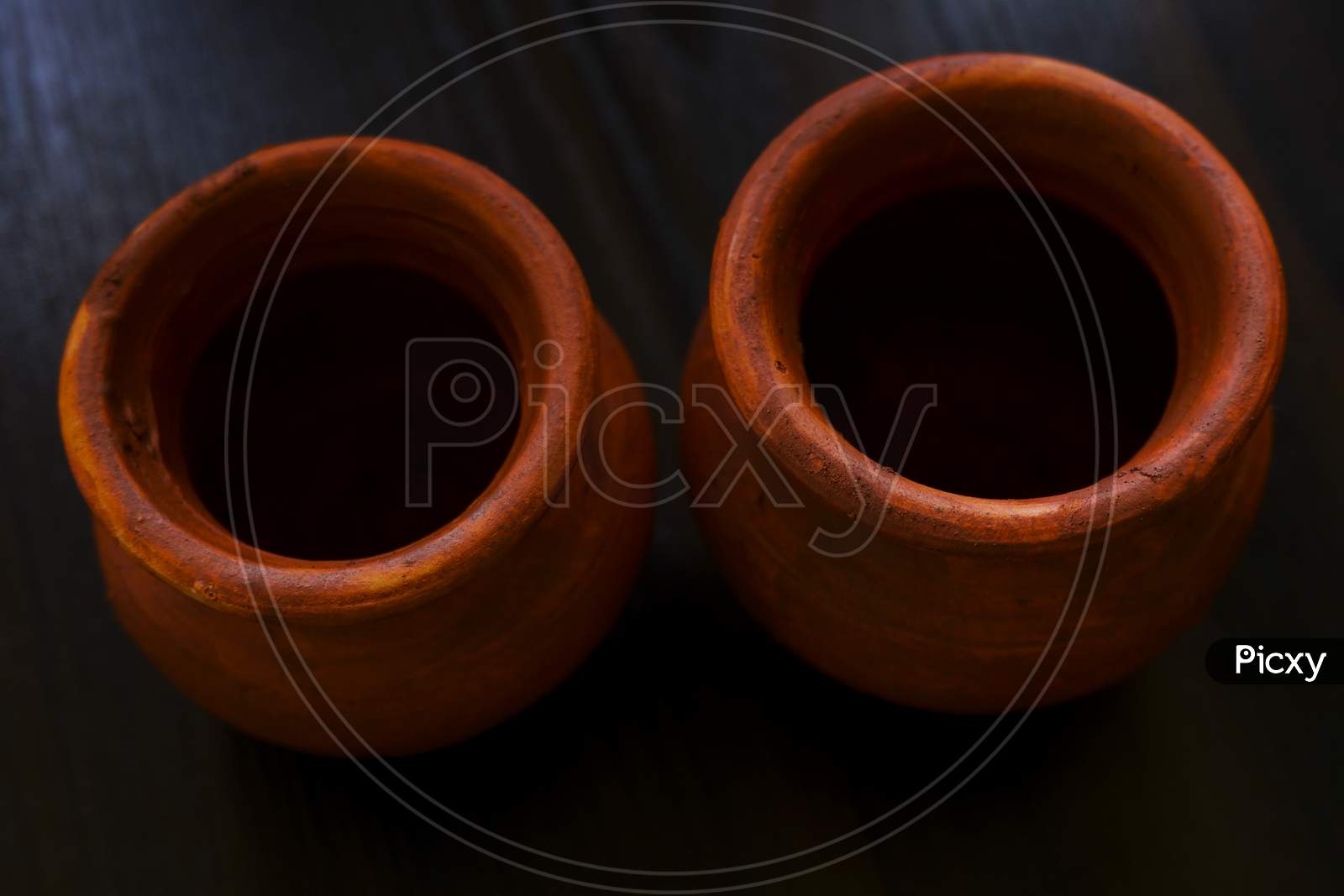 Top Shot Of Handmade Small Clay Pots Isolated On Wooden Table
