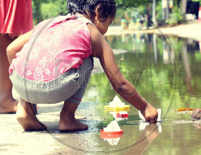 Baby girl play with paper boat