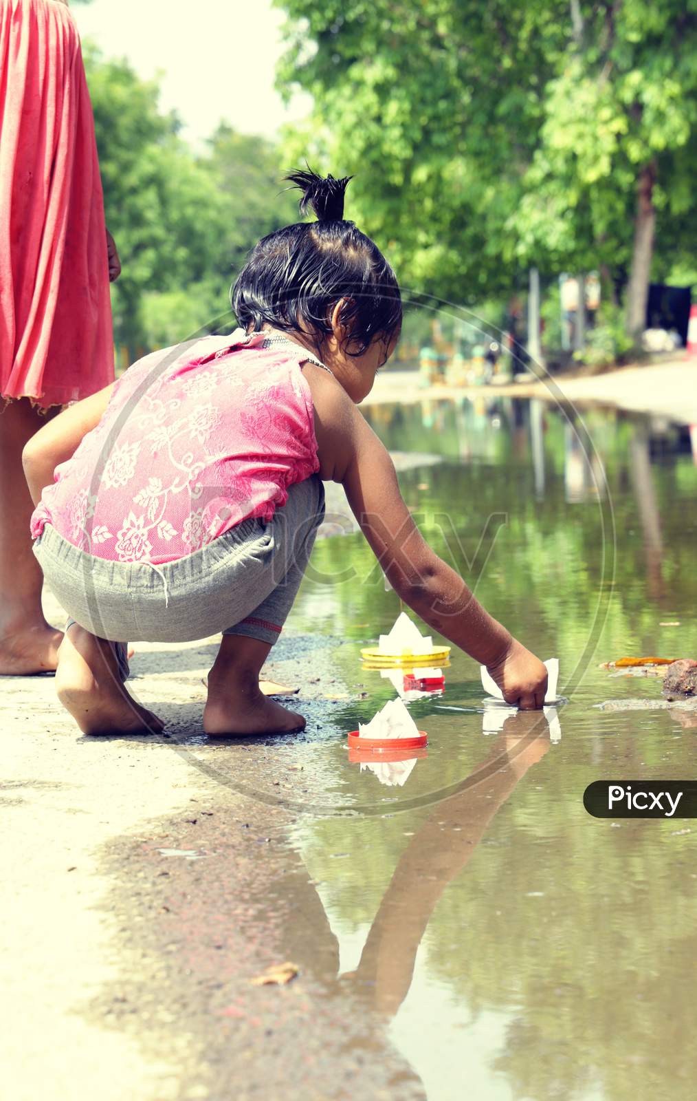 Baby girl play with paper boat