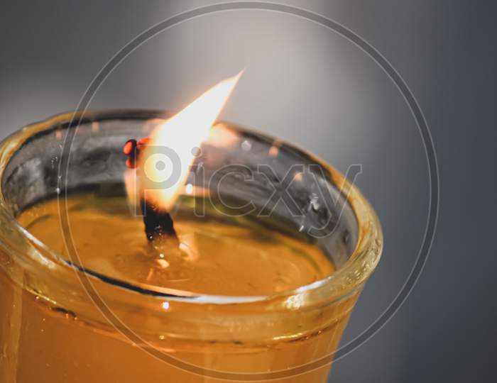 closeup of a burning candle in a glass in the dark