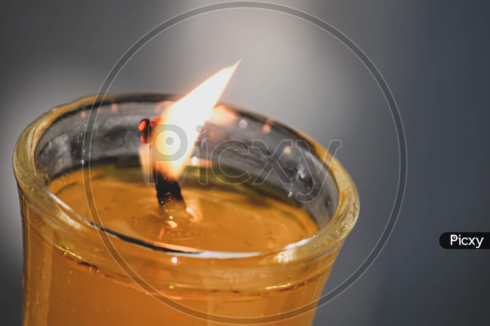 closeup of a burning candle in a glass in the dark