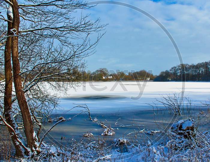 Beautiful Winter Shot At A Lake And Forest With Snow And Ice.
