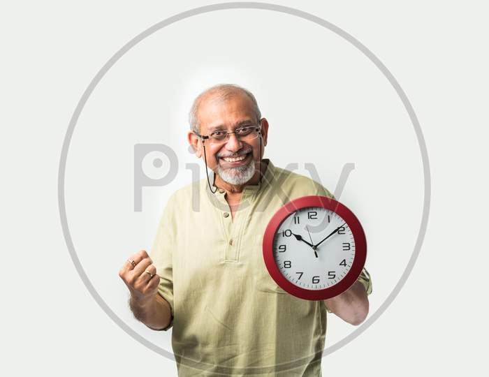 Asian Indian Old Man Holding Or Showing Round Wall Clock Or Watch