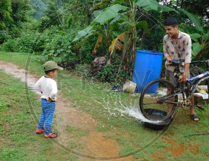 Closeup Of A Boy With A Kid Enjoying With Water Drops