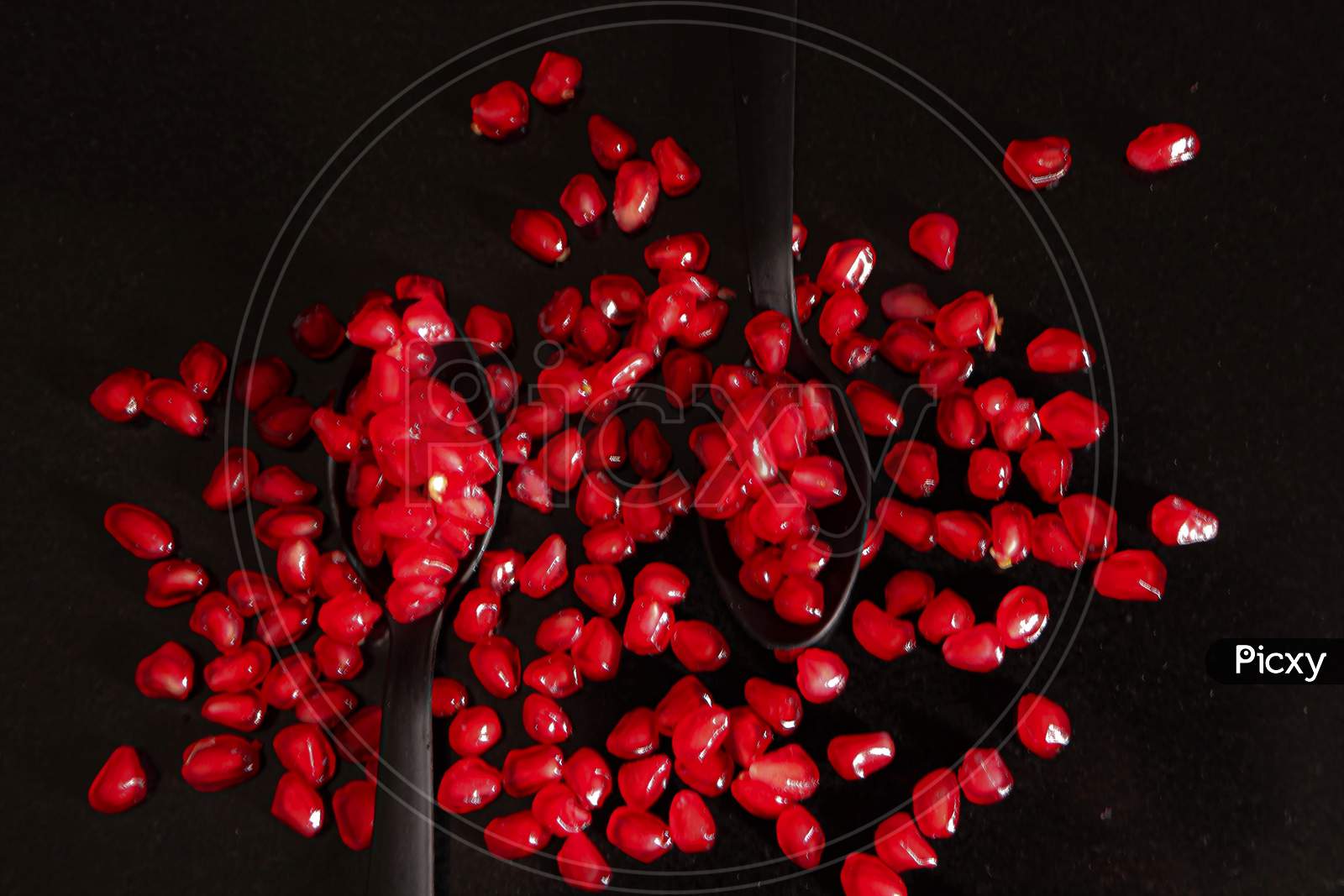 Pomegranate Seeds In Two Spoons