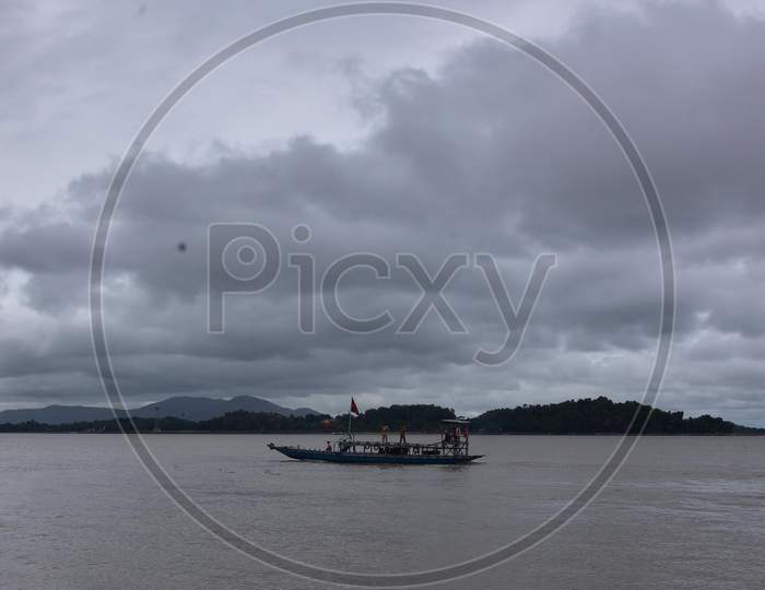A boat cross the river Brahmaputra as dark clouds gather in the sky, in Guwahati, India on 24 October 2020.