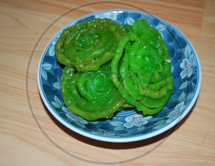 Crispy Sweet Asian Dessert Green Jalebi Cooked And Served In Ceramic Plate.