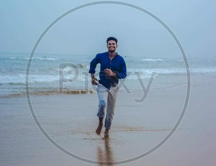 Indian men model posing on beach sea view background. Handsome and confident men. Outdoor portrait of smiling young Asian indian man on the beach.