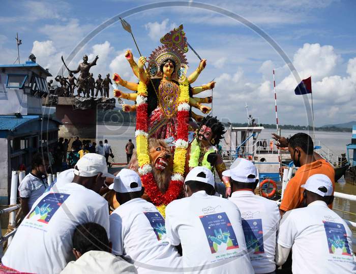 Municipal workers carry an idol of the Hindu goddess Durga for immersion in the waters of the river Brahmaputra on the last day of the Durga Puja festival in Guwahati on oct 26,2020.