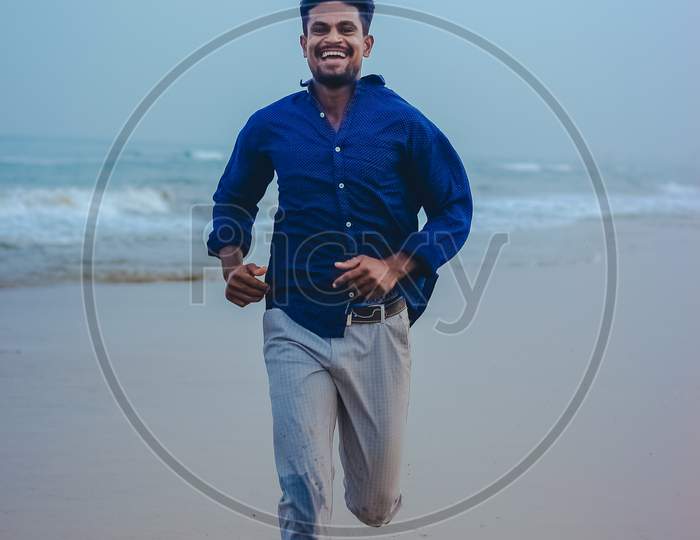 Indian men model posing on beach sea view background. Handsome and confident men. Outdoor portrait of smiling young Asian indian man on the beach.