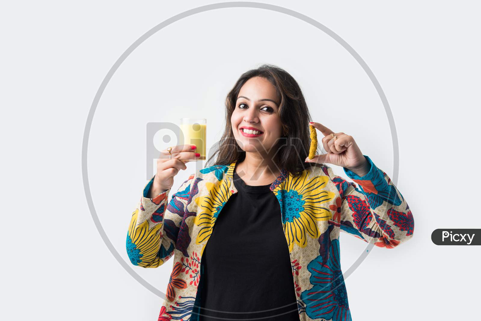 Asian Indian Pretty Girl Drinking Turmeric Milk In A Glass