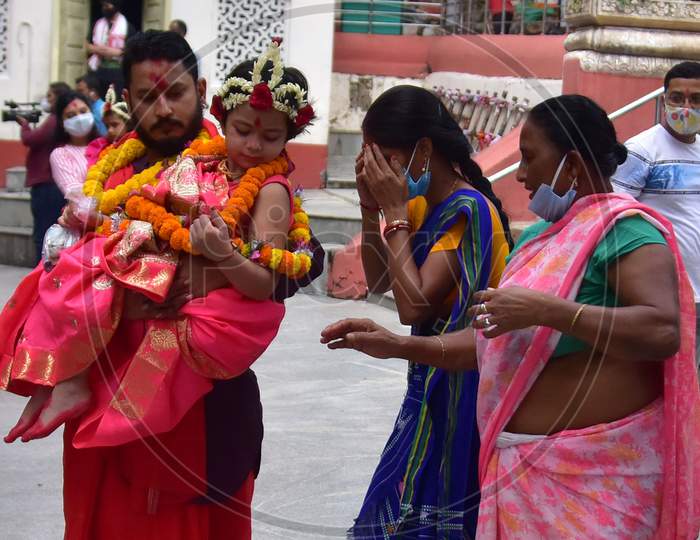 A Hindu devotee takes blessings of a girl dressed as Kumari, who is worshipped during the Durga Puja festival, at Kamakhya temple in Guwahati on Oct 25,2020.
