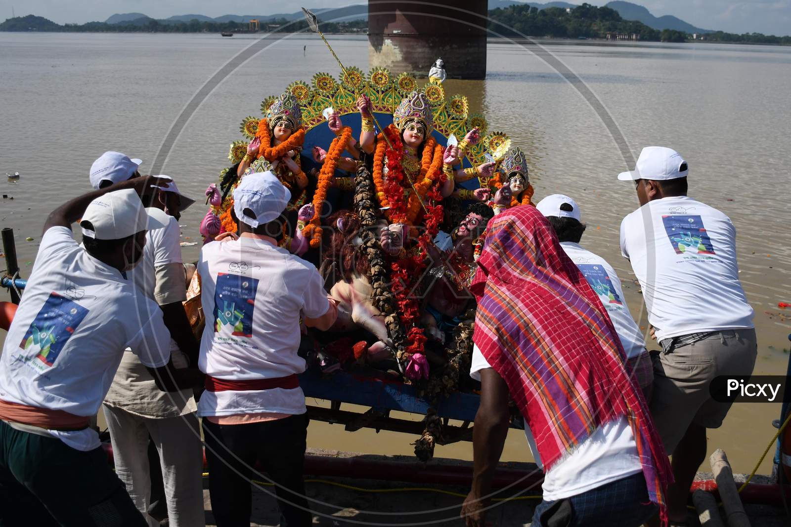 Municipal workers immerse an idol of the Hindu goddess Durga in the waters of the river Brahmaputra on the last day of the Durga Puja festival in Guwahati on Oct 26,2020.