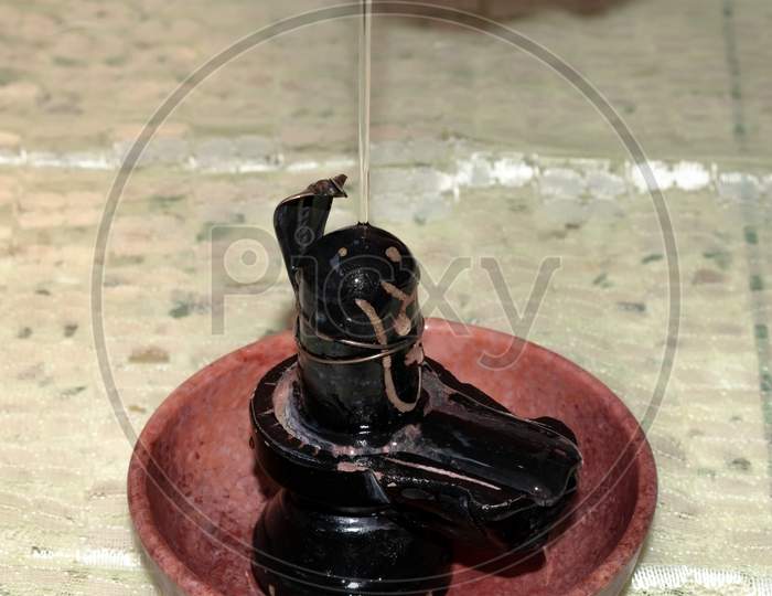 Stone sculpture of Hindu God lord Shiva linga mahadeva bathing with holy water