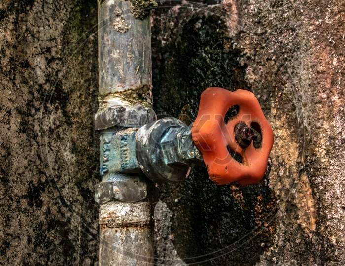 Orange color iron water gate valve on iron water supply pipe