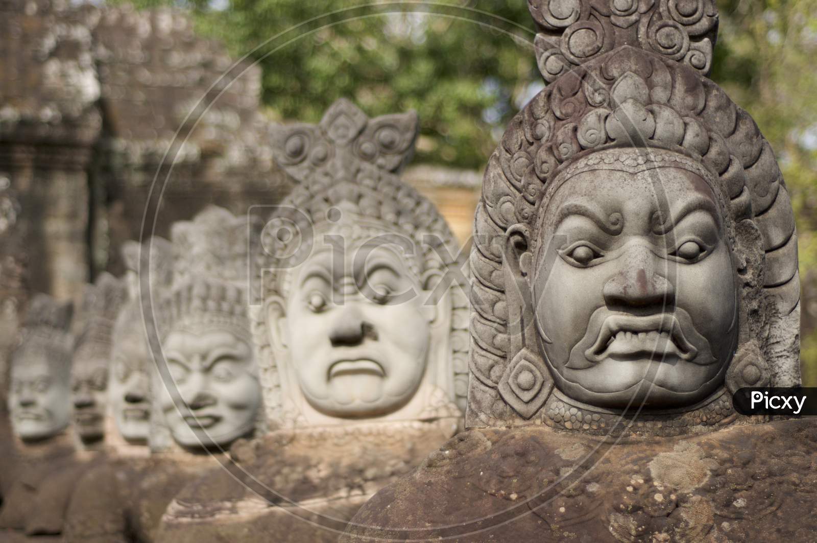 Close Up Of Asuras (Demons) Statues In A Row At The Bayon Temple Entrance Gate