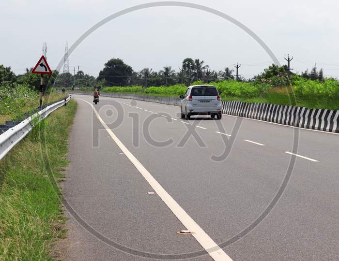 Private Vehicles And Traffic Road Sign Walking On The National Highway Road
