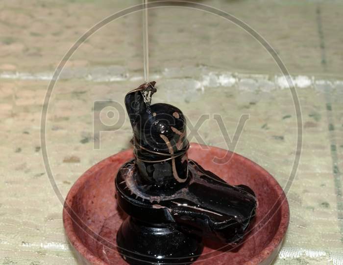 Stone sculpture of Hindu God Lord Shiva Shankara bathing with holy water snake hood on top