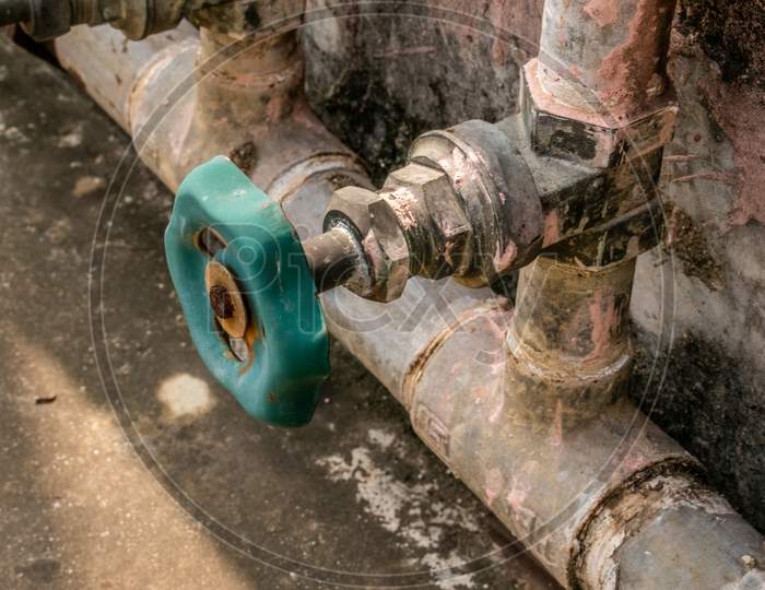 Green color rusted water gate valve on water supply pipe
