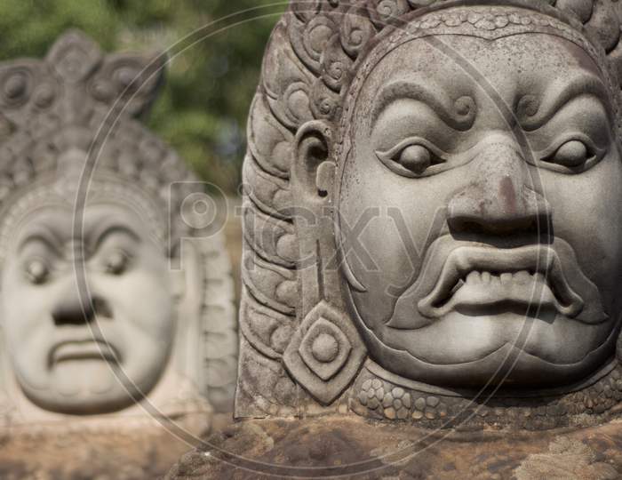 Close Up Of Asuras (Demons) Statues In A Row At The Bayon Temple Entrance Gate