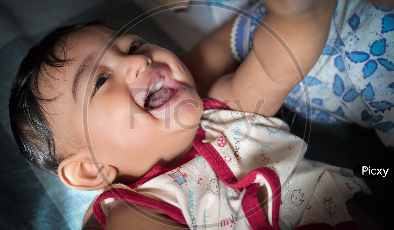 A Toddler Indian Baby Boy Smiling With First Tooth Visible On Upper Jaw With Selective Focus On Eyes