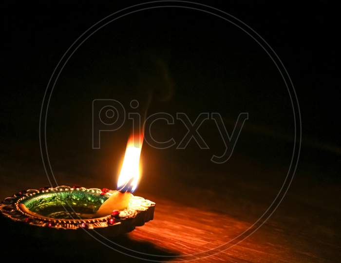 A closeup of a burning diya on the black background diwali, diya, candle, celebrate, night, background, festival