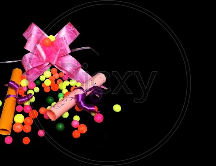 Plastic flower and small polystyrene balls on black abstract background