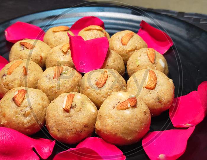 Pinni a Punjabi sweet dessert (ladoo) garnished with rose petals and almonds toppings.