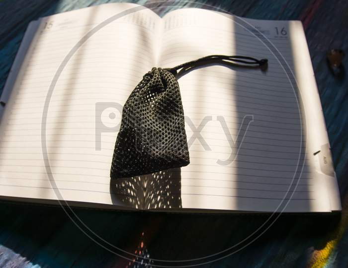 In Book Keeping The Pouch And Falling The Sunlight In Book And Pouch Color Is Black