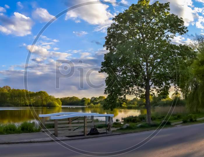 Beautiful Sunny Landscape At A Lake With A Reflective Water Surface.