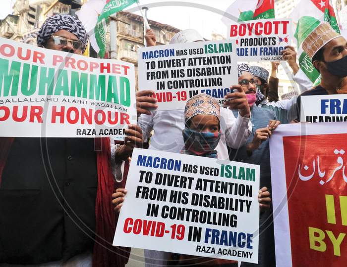 People hold placards and shout slogans during a protest against the publication of and French President Emmanuel Macron's comments over Muslim's Prophet Muhammad's caricatures, in Mumbai, India, October 28, 2020.
