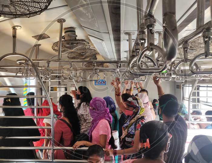 Women wearing protective face masks commute in a suburban train after authorities resumed the train services for women passengers during non-peak hours, amidst the coronavirus disease (COVID-19) outbreak, in Mumbai, India, 2020.