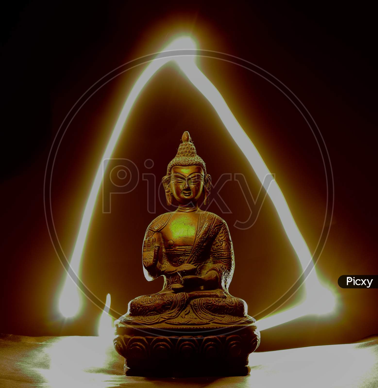 Metal buddha statue with patterns of light on the background