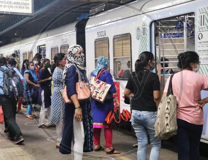 Women wearing protective face masks board a local train after authorities resumed the train services for women passengers during non-peak hours, amidst the coronavirus disease (COVID-19) outbreak, in Mumbai, India, October, 2020.