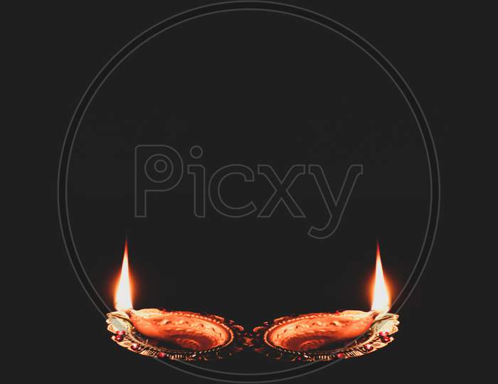 burning diyas in the dark for the occasion of celebrating Diwali, Christmas, new year, happiness, card, poster