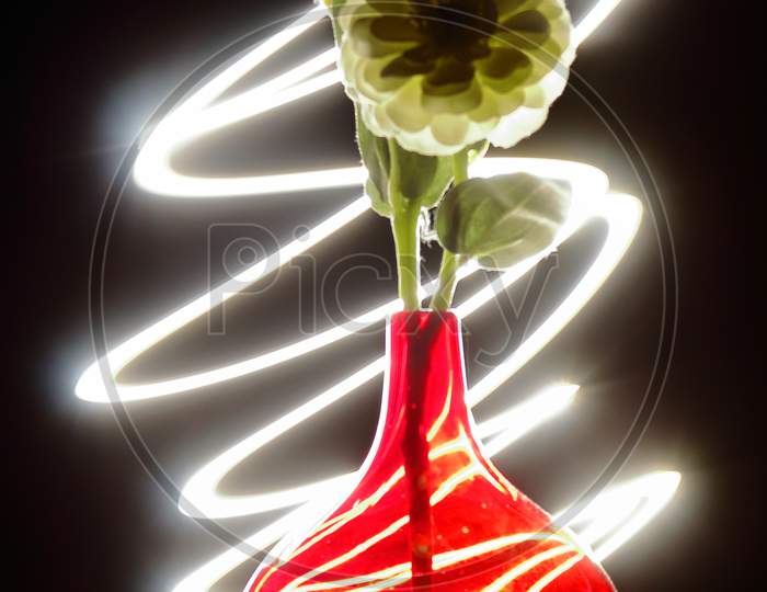 Red flower pot with light swirls in the background