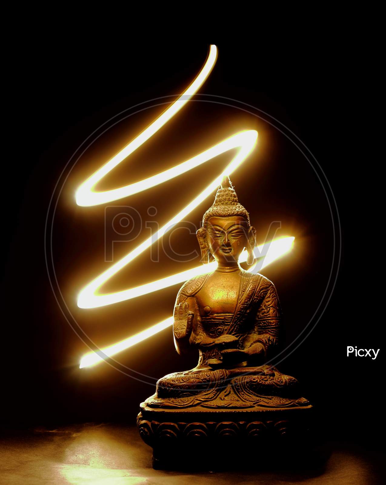 Metal buddha statue with patterns of light on the background