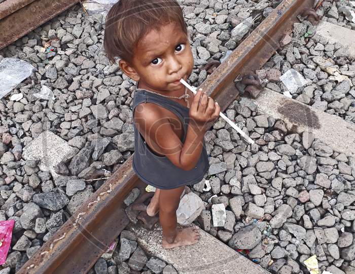 A poor child walking on the railway tracks